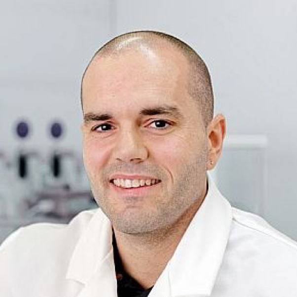 A photograph of Josep Puigmartí-Luis, wearing a white lab coat