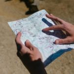 Close-up of hands holding a map during an outdoor adventure on a sunny day.