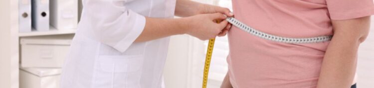 Metge mesurant la cintura d'una pacient