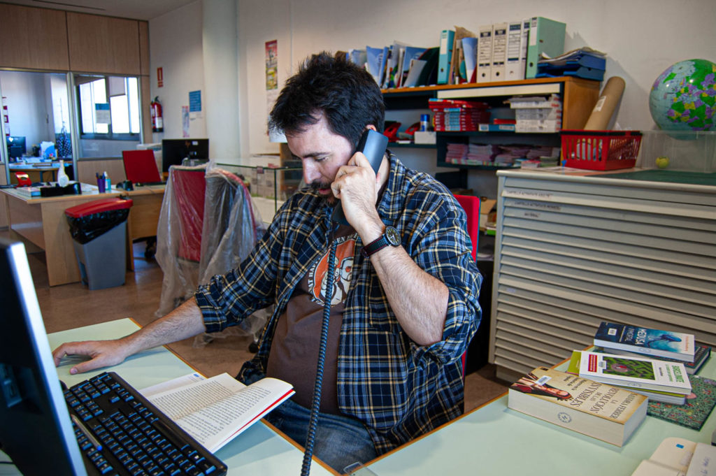El bibliotecario Cesc Llaveres leyendo un libro como parte de la iniciativa A Cau d'Orella, en la Biblioteca del Carmel, Barcelona.
