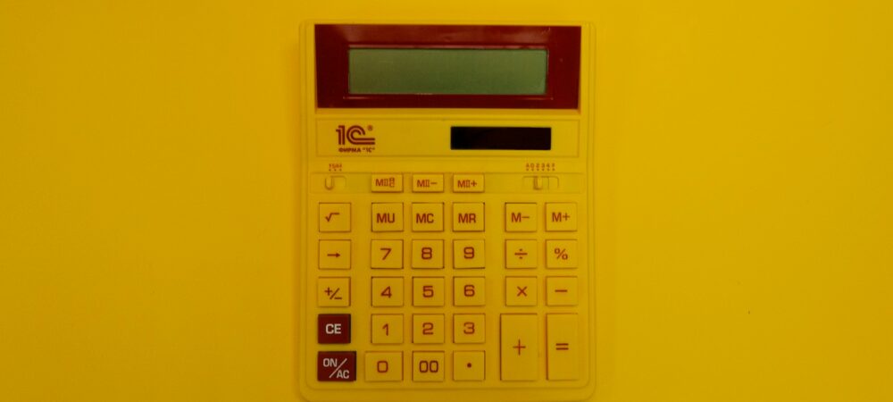 a calculator mounted on a yellow wall